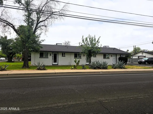 a front view of a house with a garden and outdoor seating