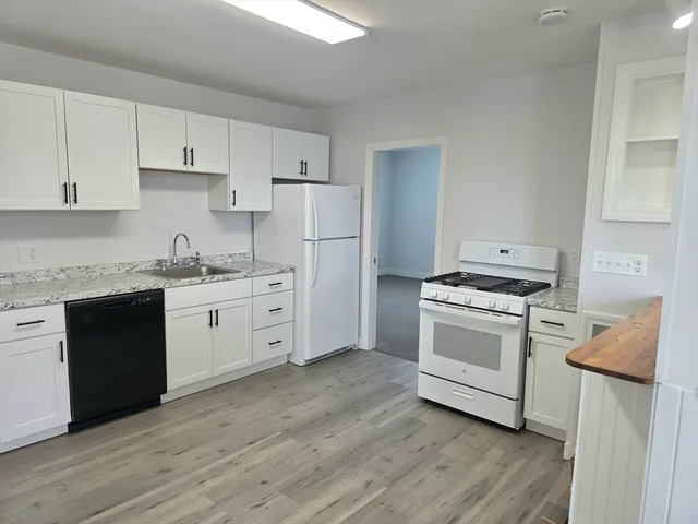 a kitchen with white cabinets sink and white appliances