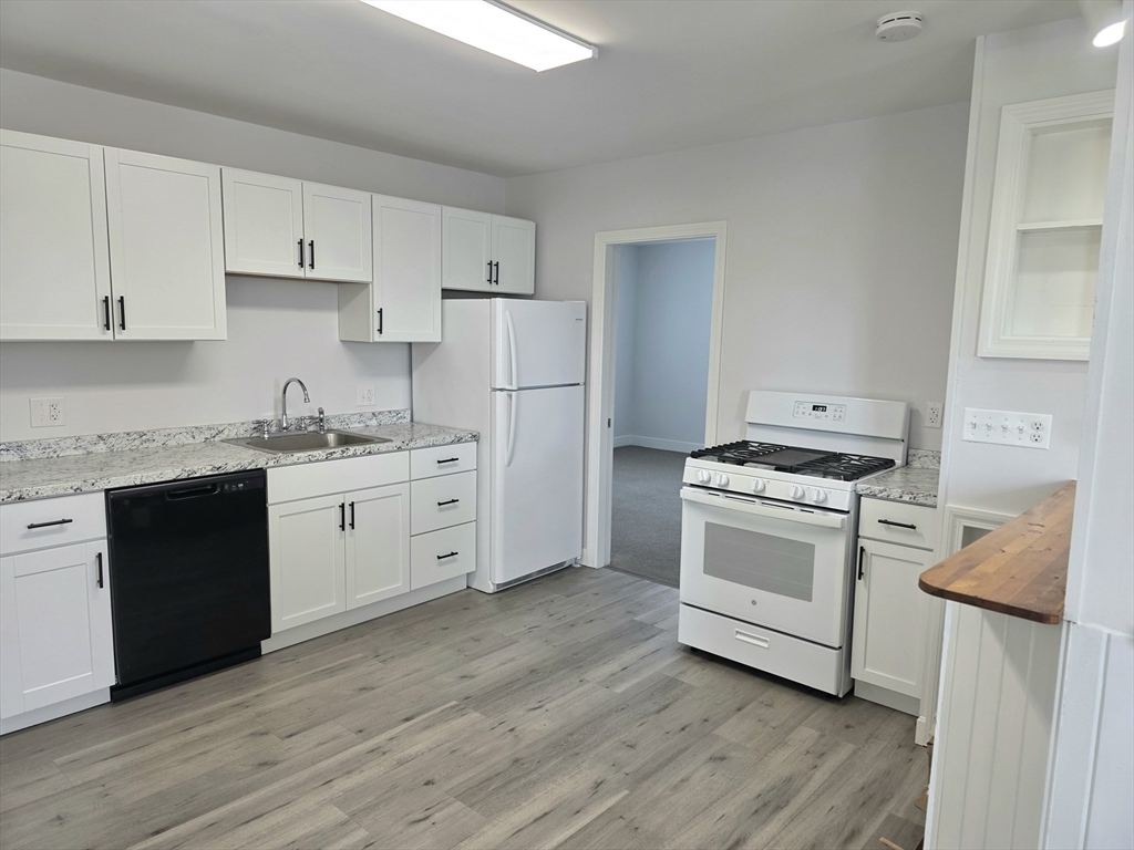 a kitchen with white cabinets sink and white appliances
