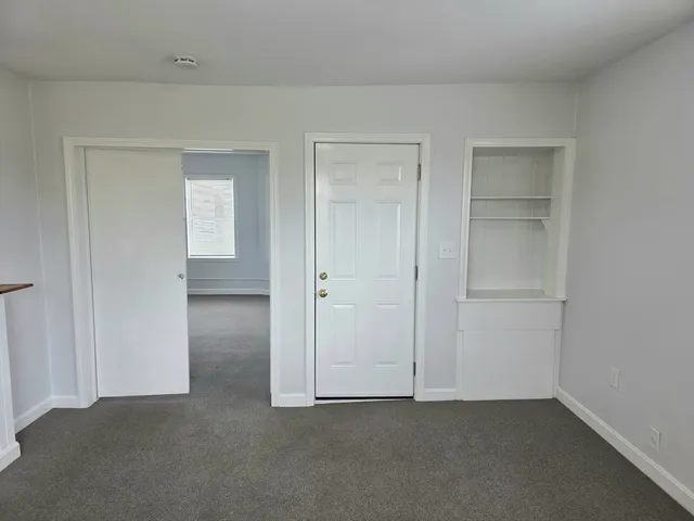 an empty room with windows and closet