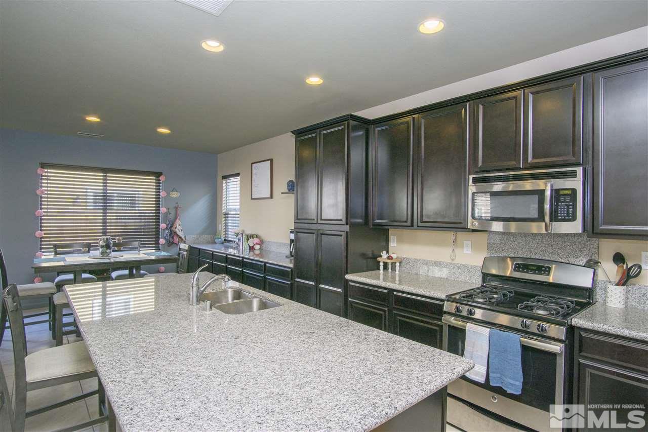 2090 Half Dome Drive Reno, NV 89521 - Photo 3 of 22 a kitchen with kitchen island granite countertop wooden cabinets and stainless steel appliances