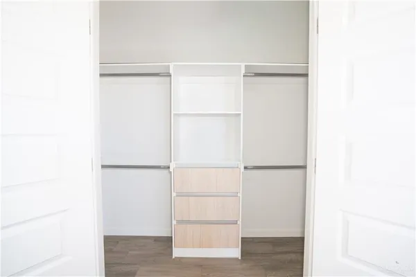 a view of walk in closet with empty racks