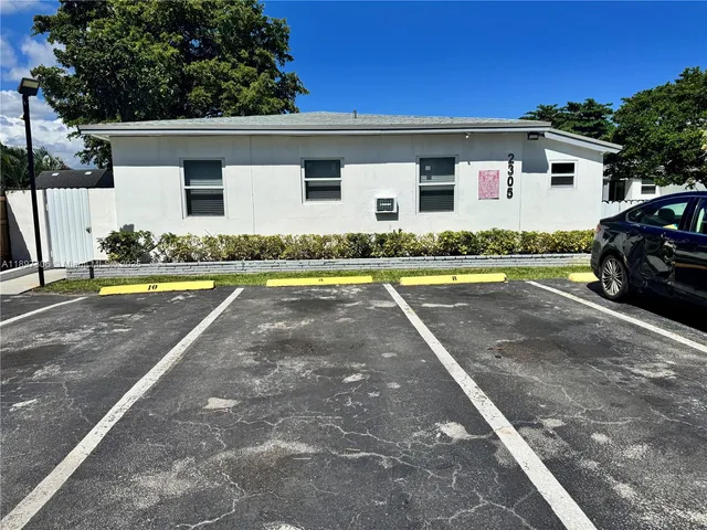 a view of a white house with swimming pool in front of it