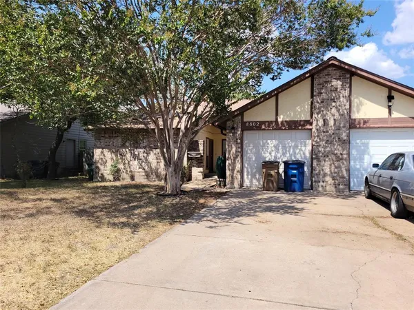 a front view of a house with yard and trees