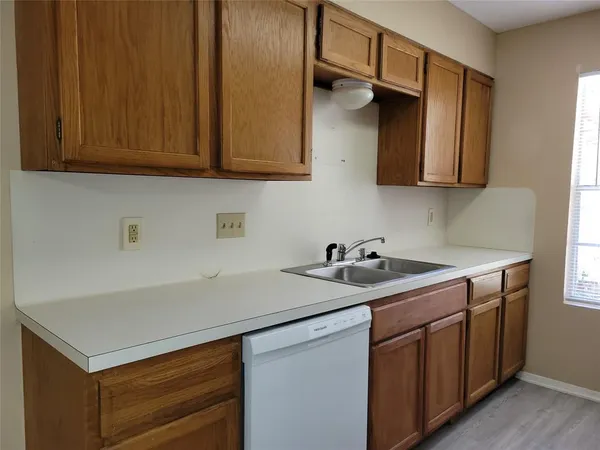 a kitchen with a sink cabinets and a wooden floor