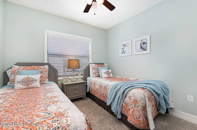 a bedroom with two beds and painting on the wall