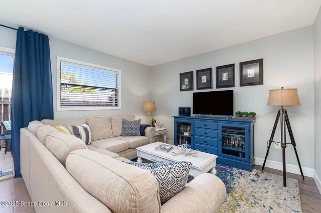 a living room with furniture a flat screen tv and a rug