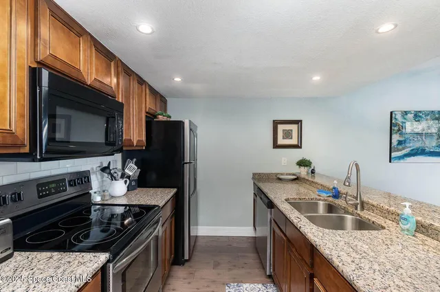a kitchen with stainless steel appliances granite countertop a sink and a microwave