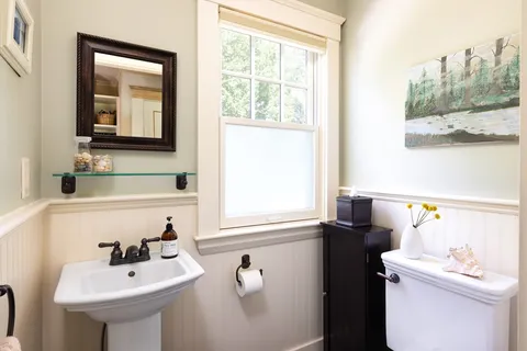 a bathroom with a sink a toilet and a mirror