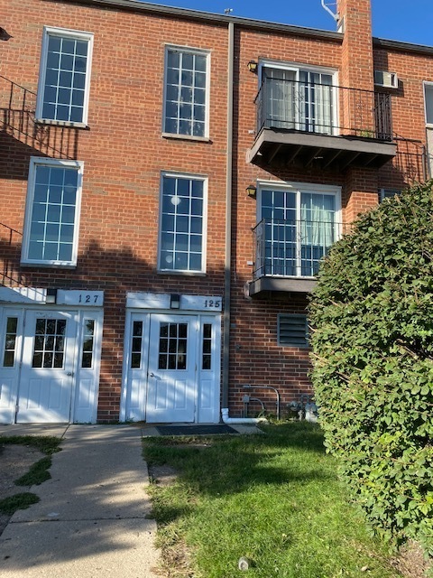 front view of a brick house with a yard