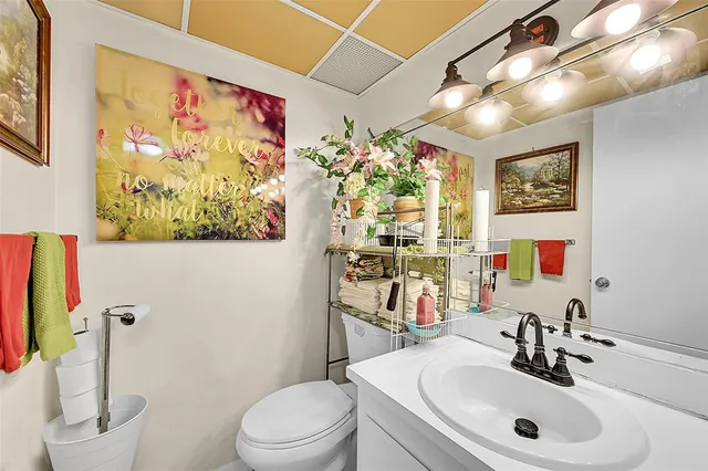 a bathroom with a sink vanity mirror and toilet