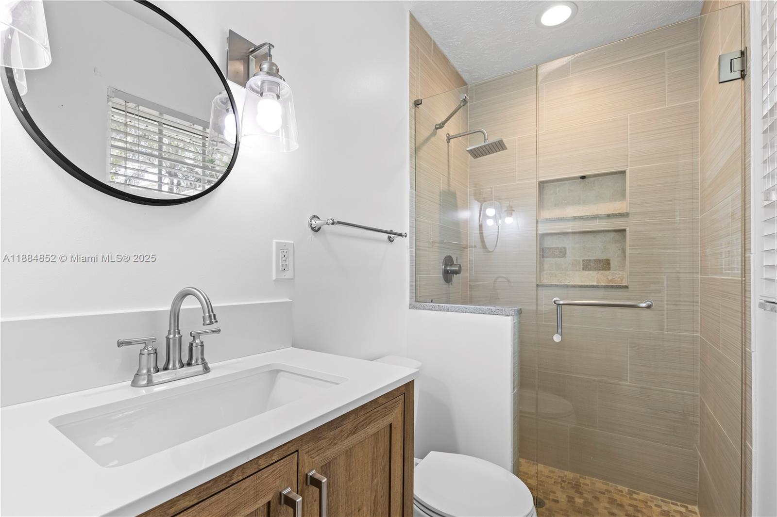 1517 Southeast Pitcher Road Port St. Lucie, FL 34952 - Photo 10 of 26 a bathroom with a sink a toilet and a mirror