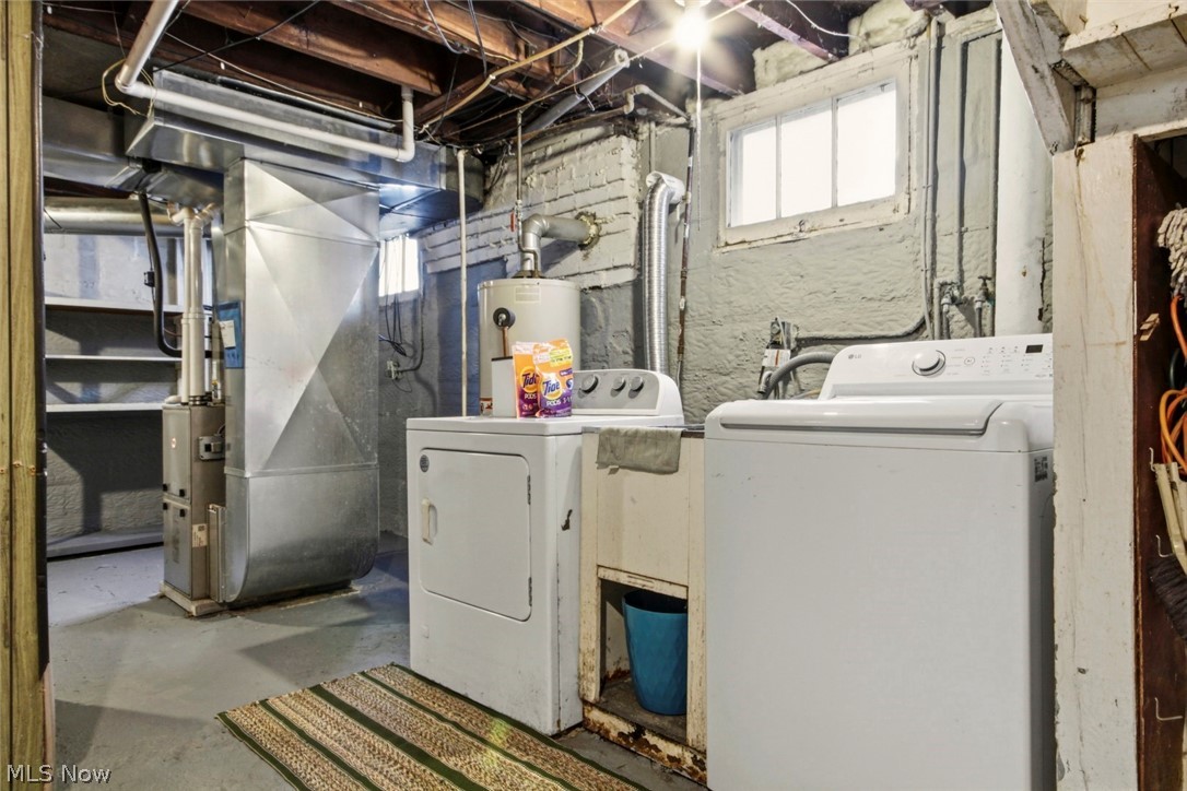 32 Como Street Struthers, OH 44471 - Photo 21 of 22 Laundry area featuring concrete floors, heating unit, water heater, and washing machine and clothes dryer