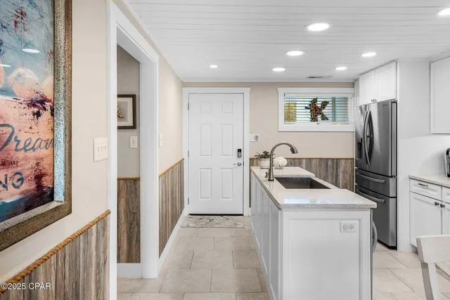 a kitchen with kitchen island granite countertop a stove sink microwave and refrigerator