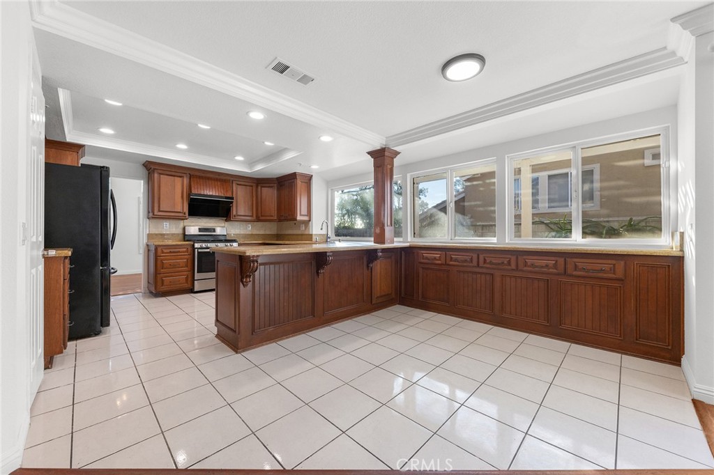 6598 Bradford Court Rancho Cucamonga, CA 91701 - Photo 18 of 48 a kitchen with stainless steel appliances kitchen island granite countertop a stove and a sink