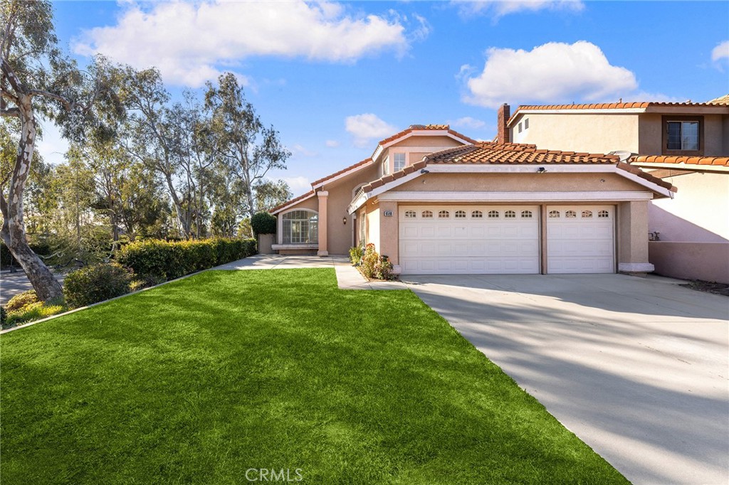6598 Bradford Court Rancho Cucamonga, CA 91701 - Photo 4 of 48 a front view of a house with a garden and yard