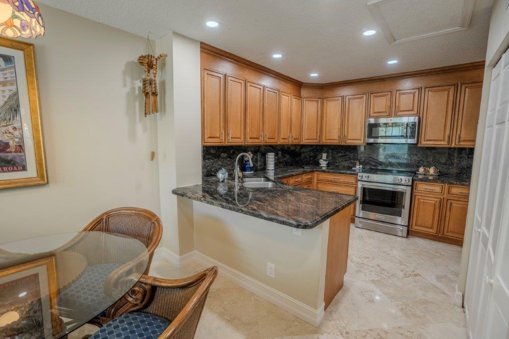 708 Mainsail Circle Jupiter, FL 33477 - Photo 27 of 68 a kitchen with granite countertop kitchen island stainless steel appliances a stove a sink a refrigerator a counter top space and cabinets