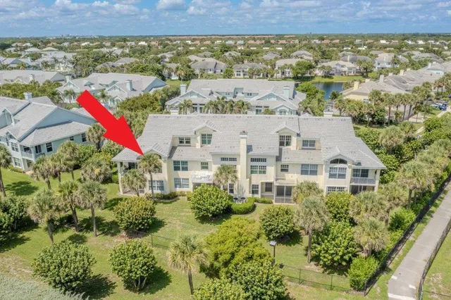 an aerial view of a house with a yard and lake