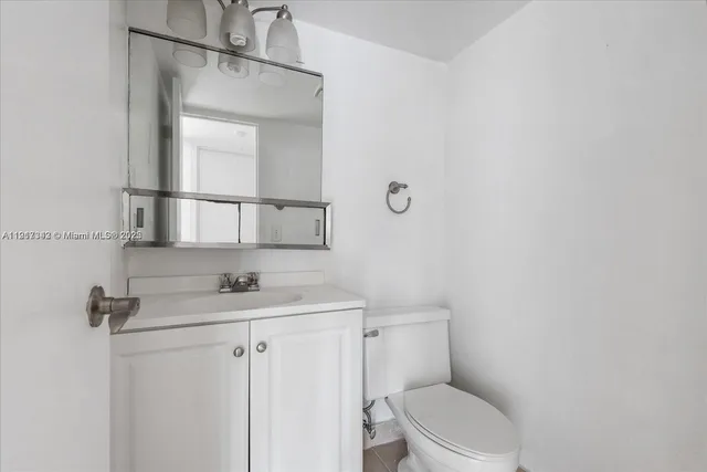 a bathroom with a granite countertop toilet sink and mirror