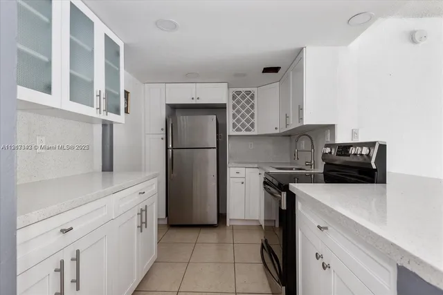 a kitchen with stainless steel appliances a refrigerator sink and cabinets