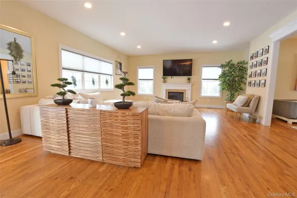 a dining room with wooden floor a chandelier a wooden table and chairs