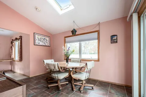 a dining room with wooden floor and a window