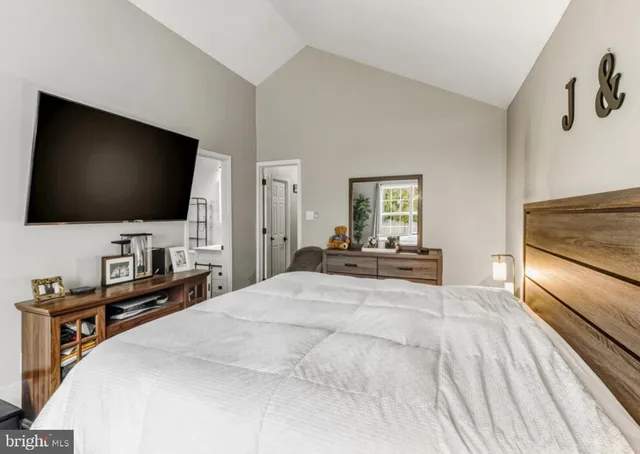 a bedroom with a bed and a flat tv screen on wall