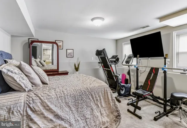 a bedroom with a bed a flat screen tv and a book shelf