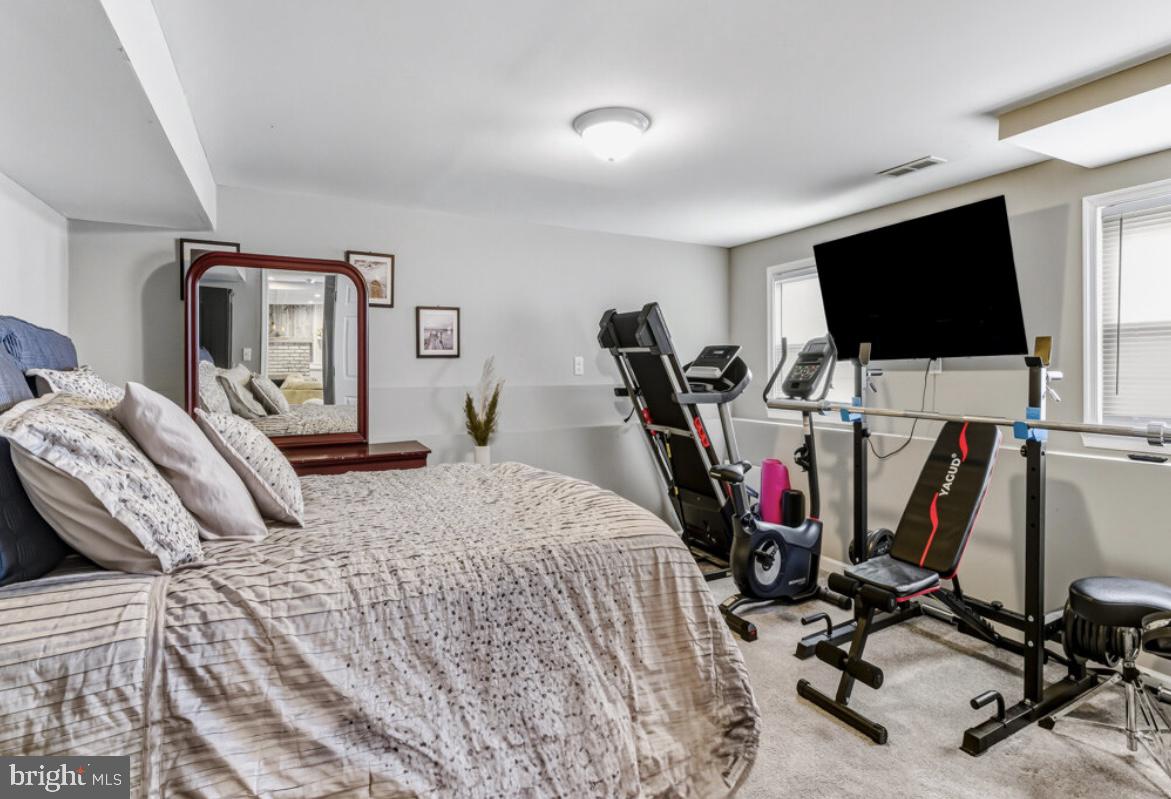 27 Lincoln Drive Clementon, NJ 08021 - Photo 22 of 31 a bedroom with a bed a flat screen tv and a book shelf