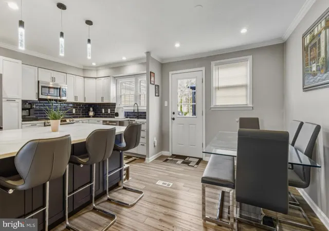 a living room with stainless steel appliances kitchen island granite countertop furniture and a refrigerator