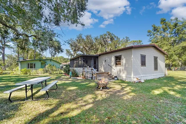 a view of a house with backyard and sitting area