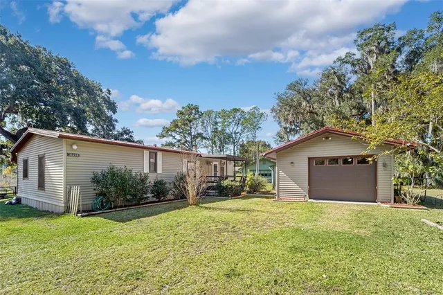 a front view of house with yard and trees in the background