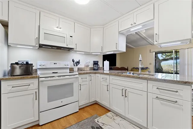 a kitchen with white cabinets stainless steel appliances and sink