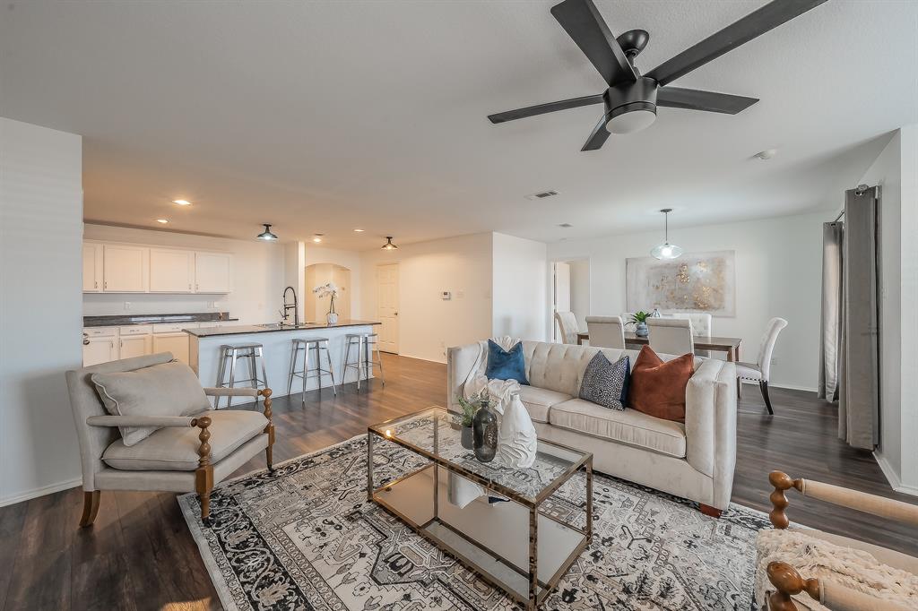 a living room with furniture and a view of kitchen