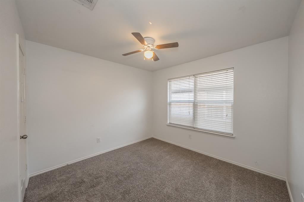 10541 Rising Knoll Lane Fort Worth, TX 76131 - Photo 18 of 27 an empty room with chandelier fan and windows