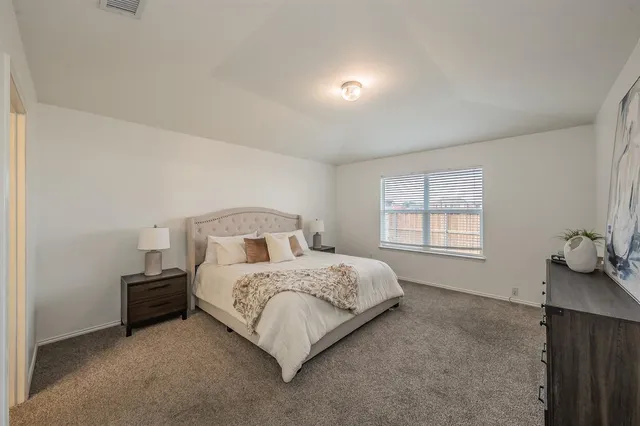 an empty room with chandelier fan and windows