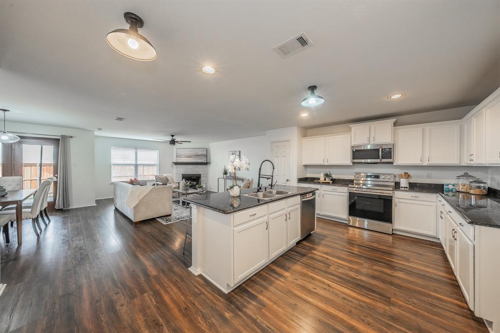 10541 Rising Knoll Lane Fort Worth, TX 76131 - Photo 26 of 27 a kitchen with counter top space a sink wooden floor and stainless steel appliances