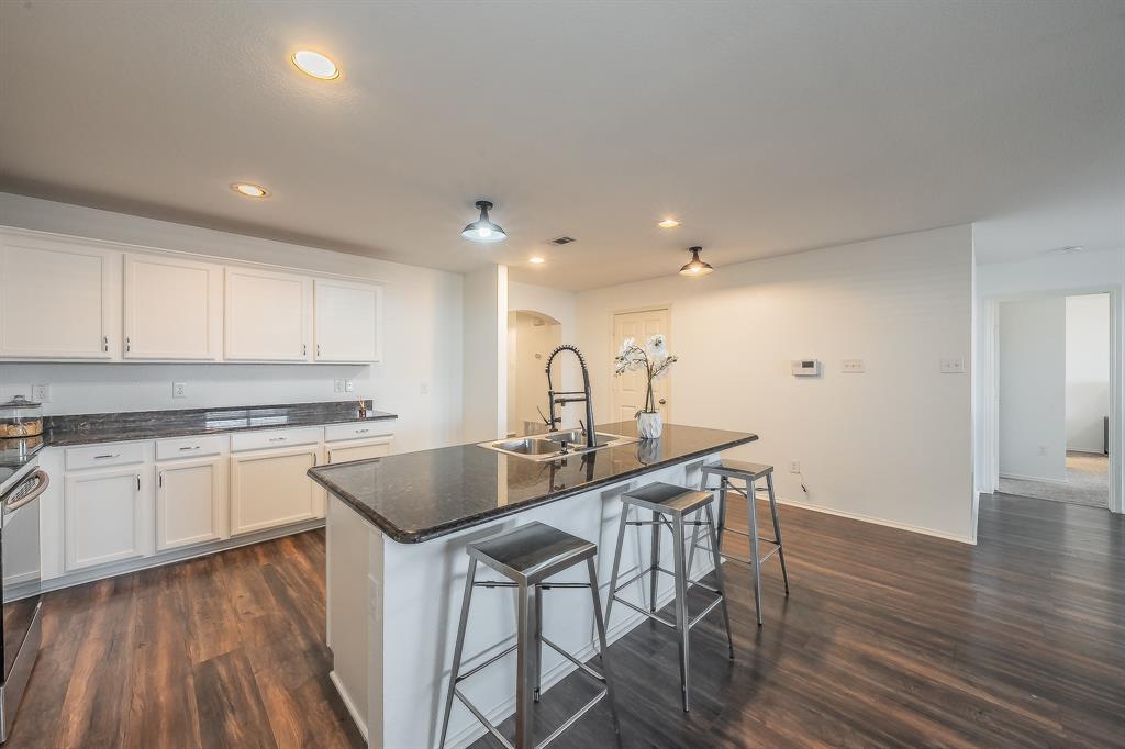 10541 Rising Knoll Lane Fort Worth, TX 76131 - Photo 7 of 27 a kitchen with kitchen island a sink table and chairs