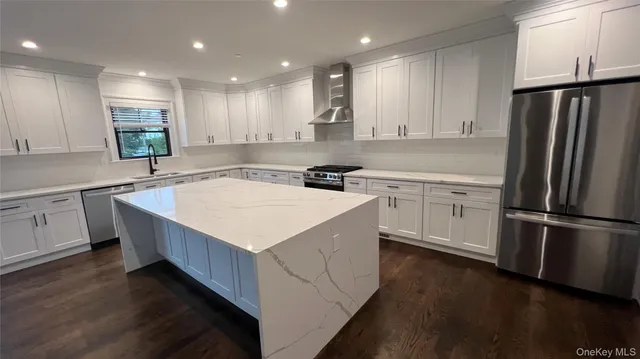 a kitchen with a sink a refrigerator a oven and white cabinets