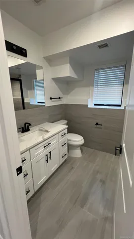 a spacious bathroom with a toilet sink and mirror