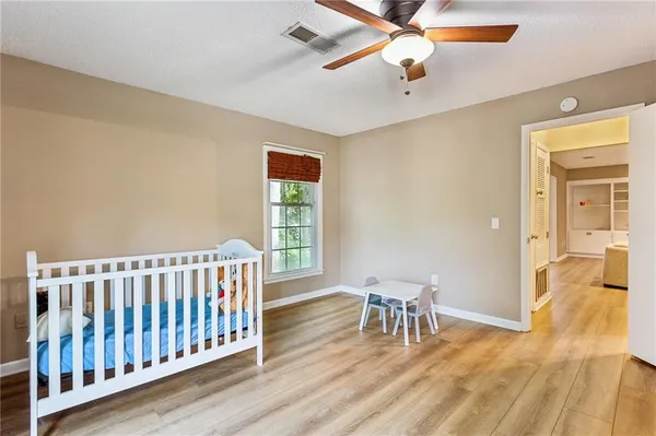 a view of a room with wooden floor ceiling fan and windows