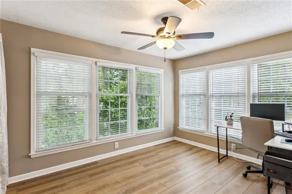 a view of a livingroom with wooden floor and a ceiling fan