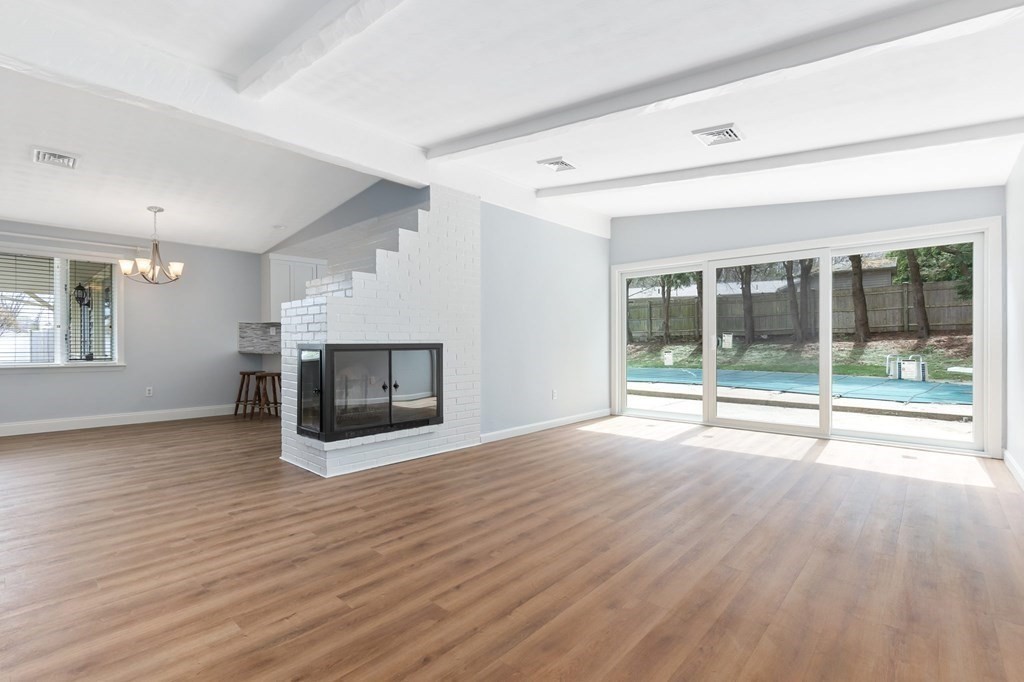42 Amherst Road Beverly, MA 01915 - Photo 4 of 23 a view of empty room with wooden floor and fireplace