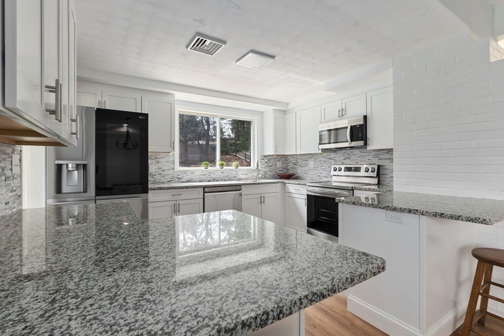 42 Amherst Road Beverly, MA 01915 - Photo 8 of 23 a kitchen with stainless steel appliances granite countertop a stove a sink and a microwave