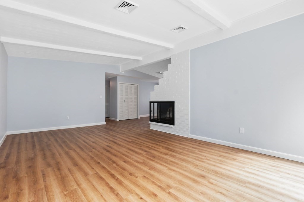 42 Amherst Road Beverly, MA 01915 - Photo 10 of 23 a view of empty room with wooden floor and fireplace