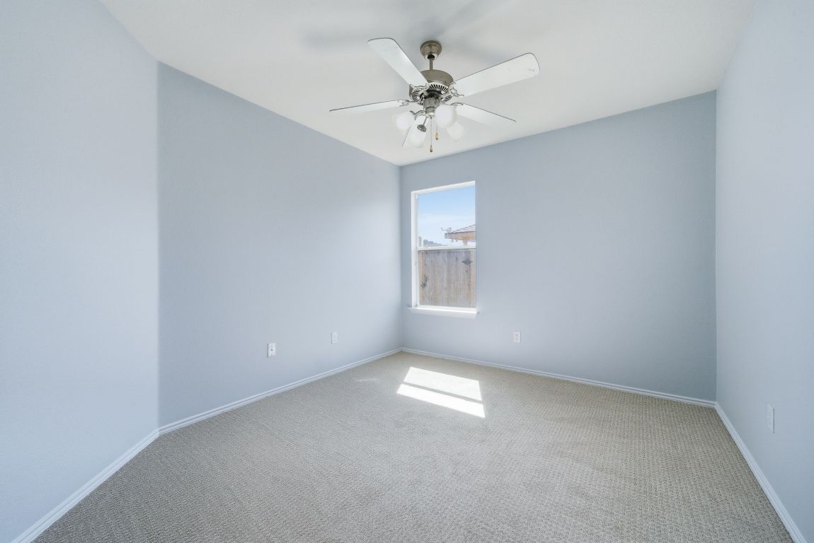 18153 Basket Flower Bend Elgin, TX 78621 - Photo 17 of 35 an empty room with a chandelier fan and windows