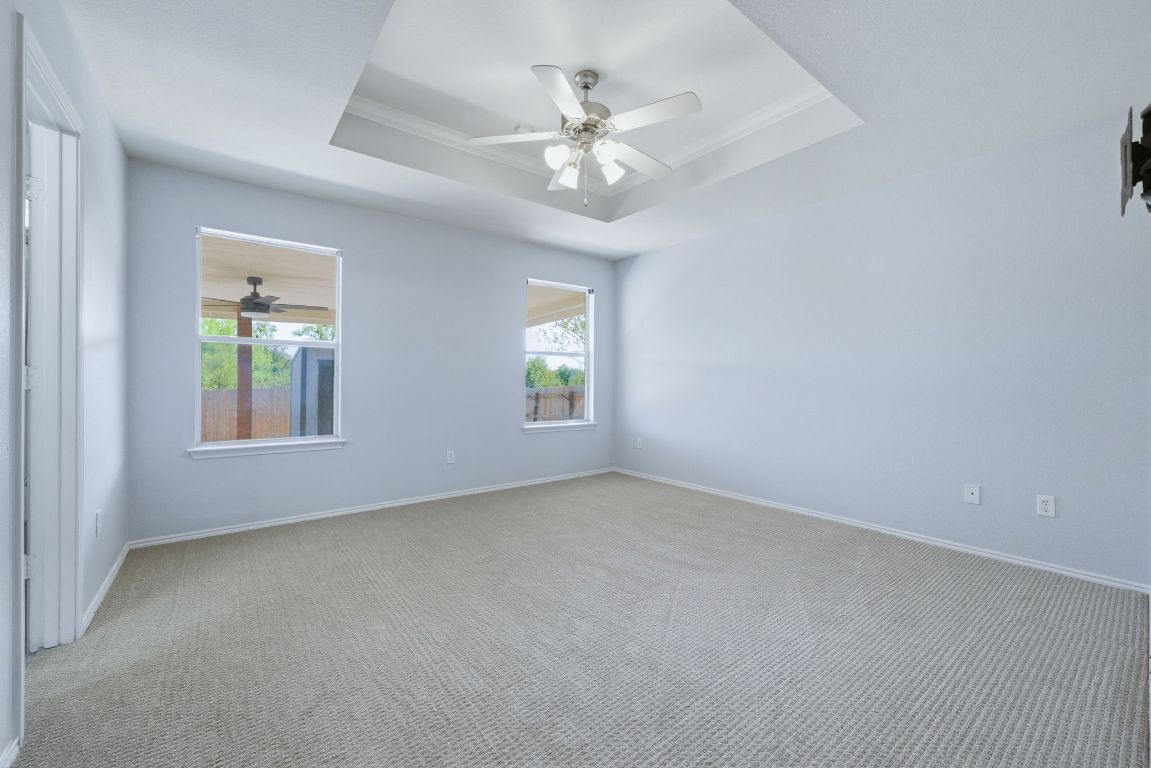 18153 Basket Flower Bend Elgin, TX 78621 - Photo 24 of 35 an empty room with a chandelier fan and windows