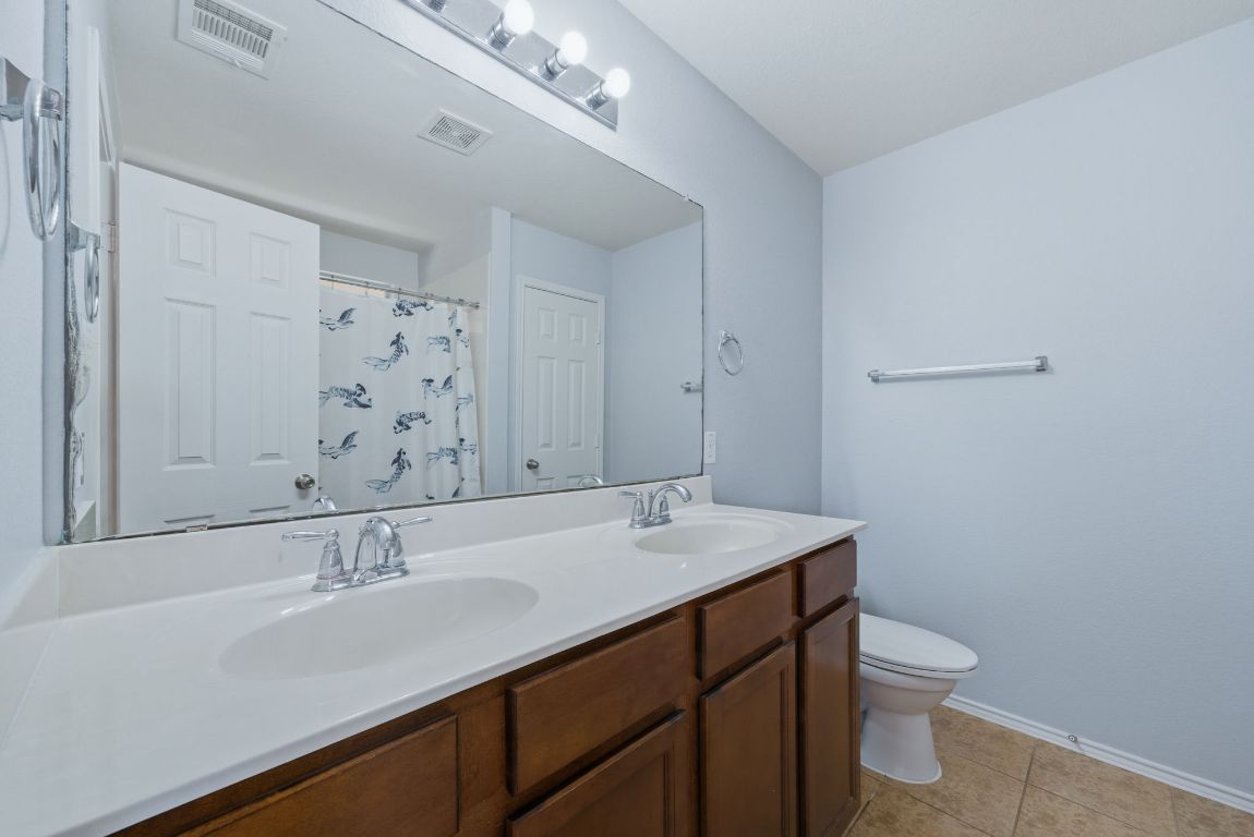 18153 Basket Flower Bend Elgin, TX 78621 - Photo 25 of 35 a bathroom with a sink a toilet and shower
