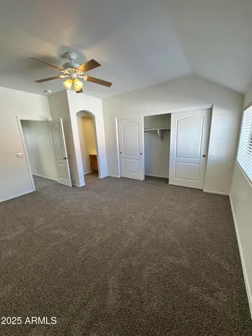 en empty room with windows and ceiling fan