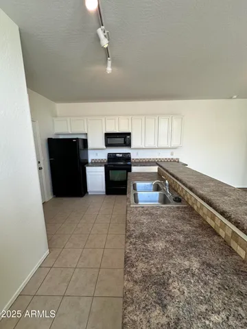 a kitchen with stainless steel appliances granite countertop a refrigerator and a stove top oven